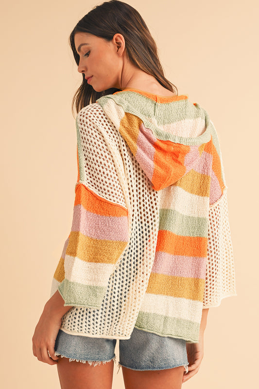 Woman wearing a colorful striped sweater with a neutral background