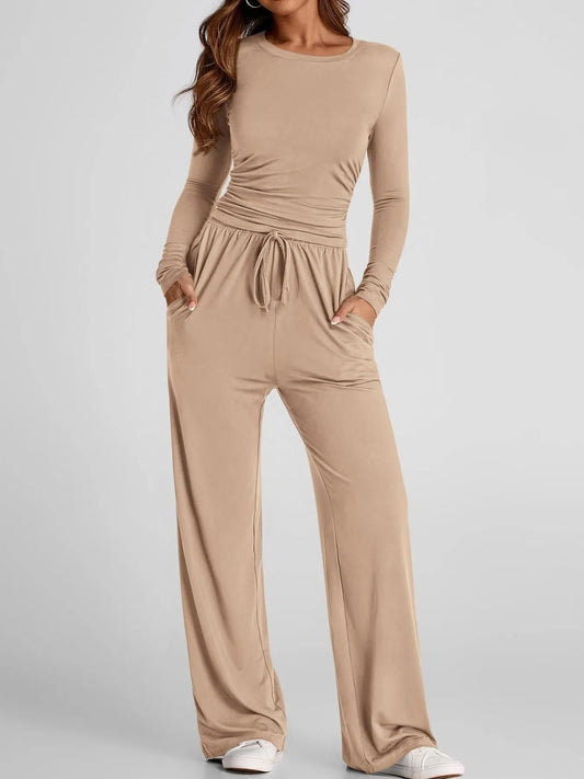 Beige jumpsuit worn by a model on a light gray background