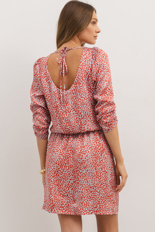 Woman wearing a red and white patterned dress with a plain background