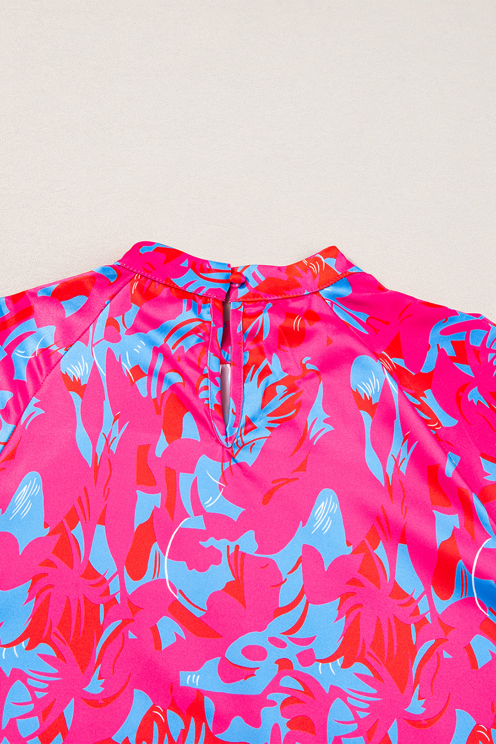 Pink and blue floral patterned garment on a light beige background