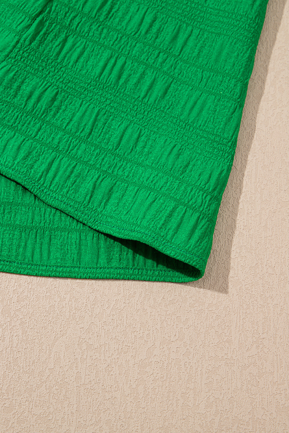 Close-up of green textured fabric on a beige background