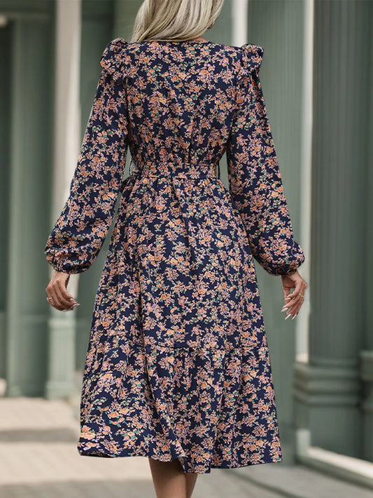 Woman wearing a floral dress with long sleeves in an outdoor setting