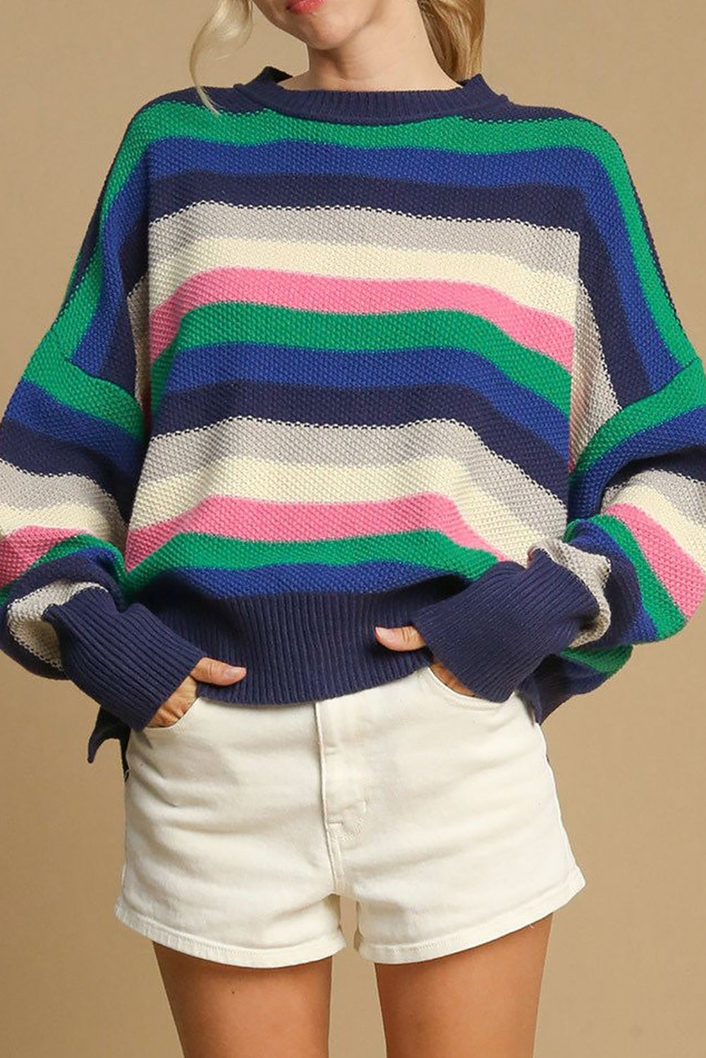 Multicolored striped sweater worn by a person on a beige background