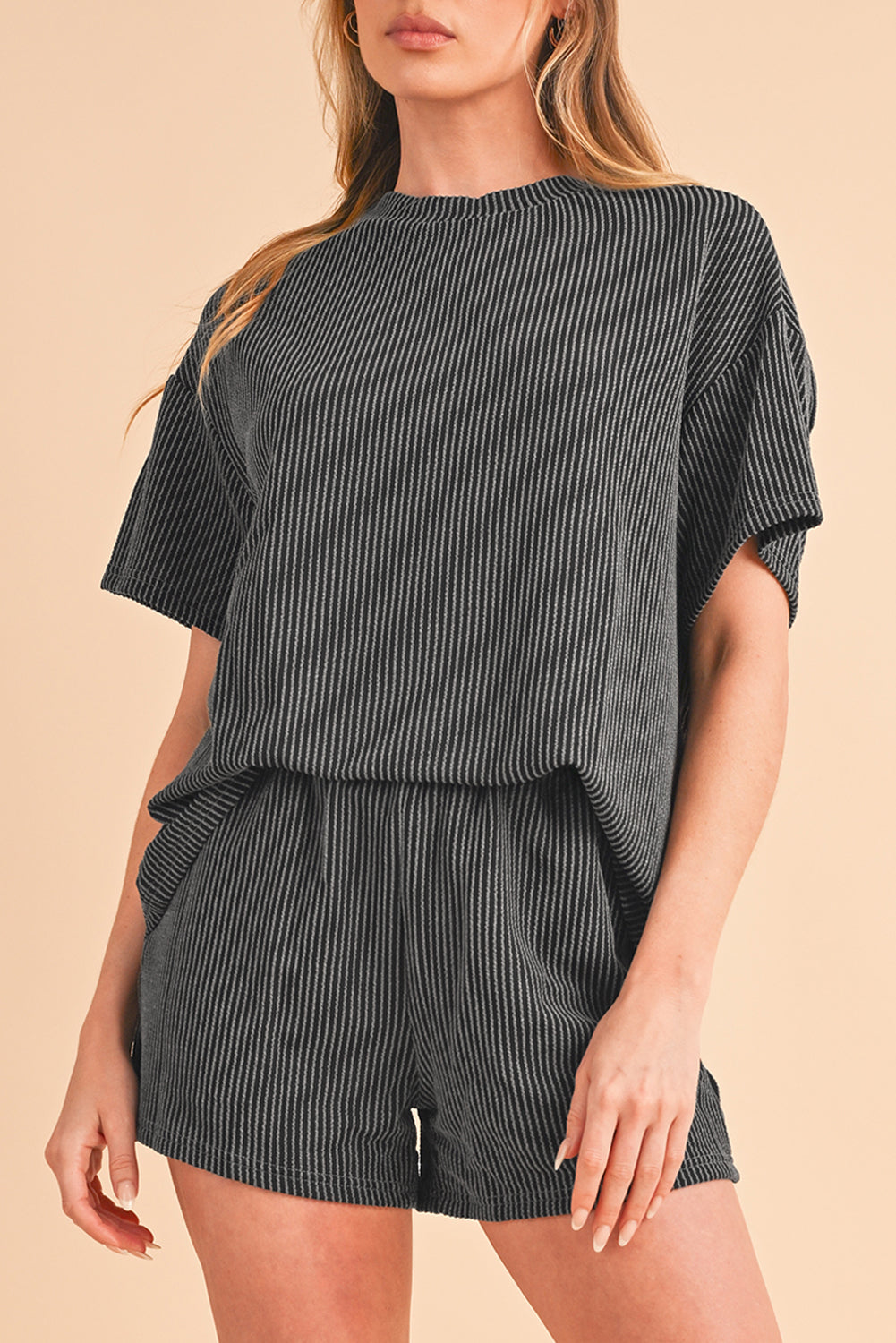 Woman wearing a black and white striped romper on a beige background