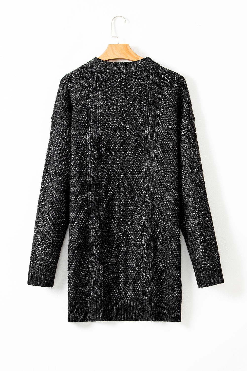 Black knitted cardigan on a hanger against a white background