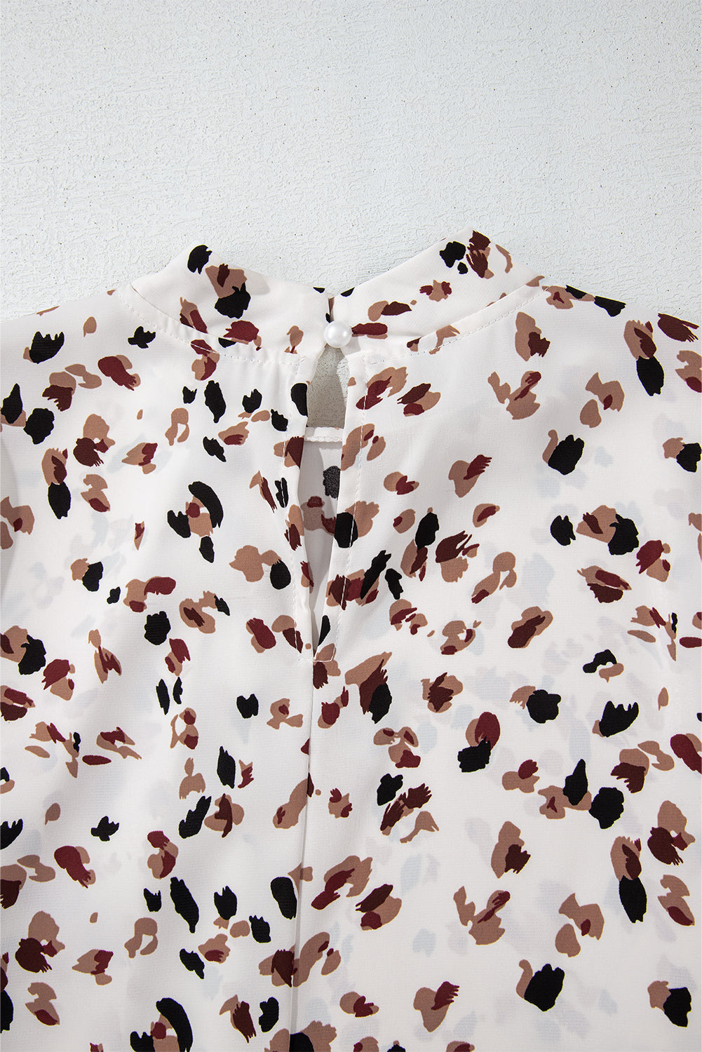 Close-up of a patterned fabric with brown and black dots on a white background