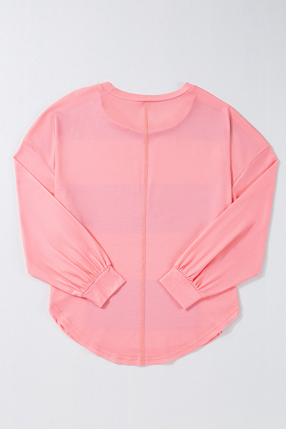 Pink long-sleeve top on a light gray background