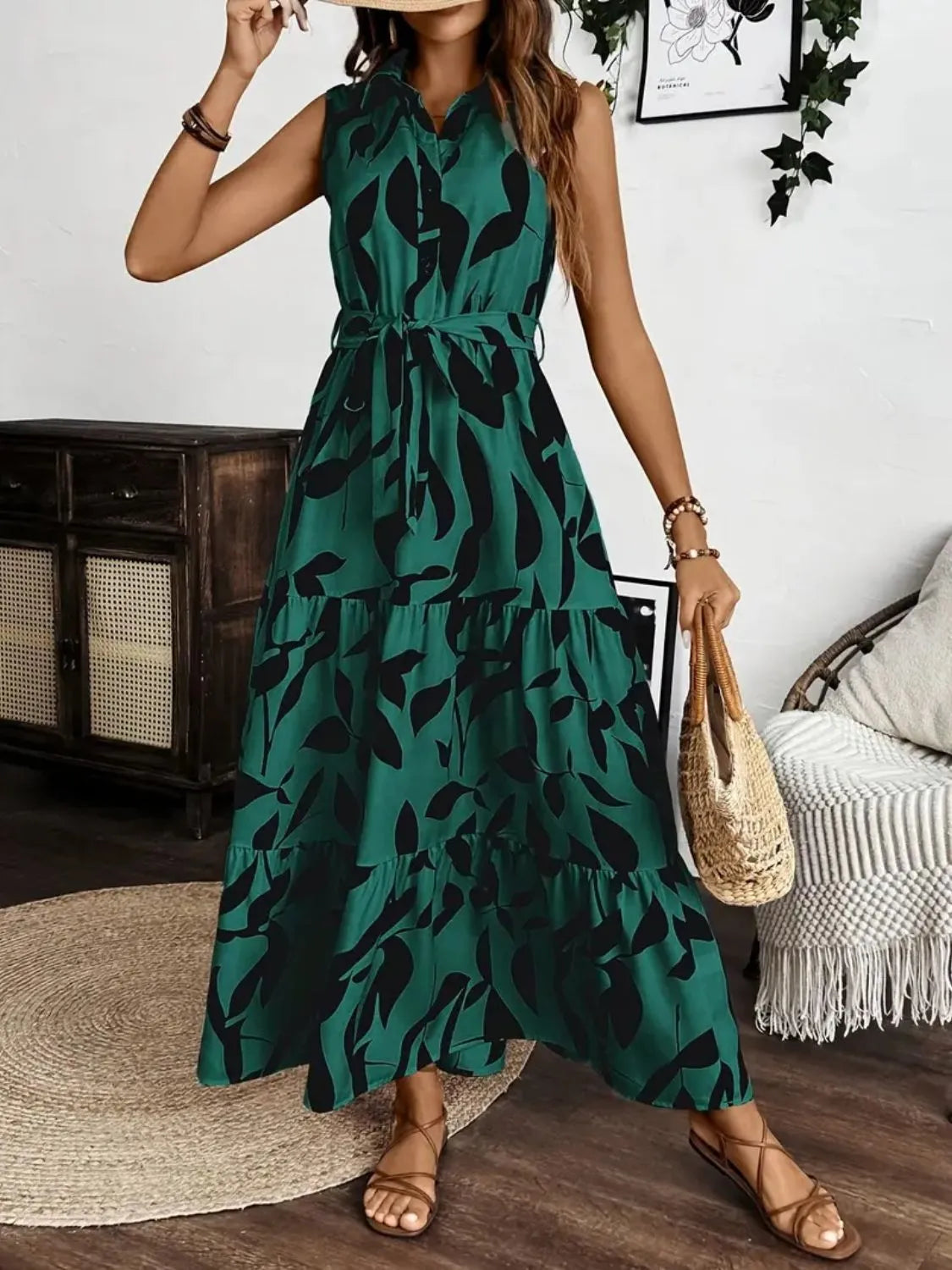 Woman wearing a green dress with black leaf pattern in a room setting.