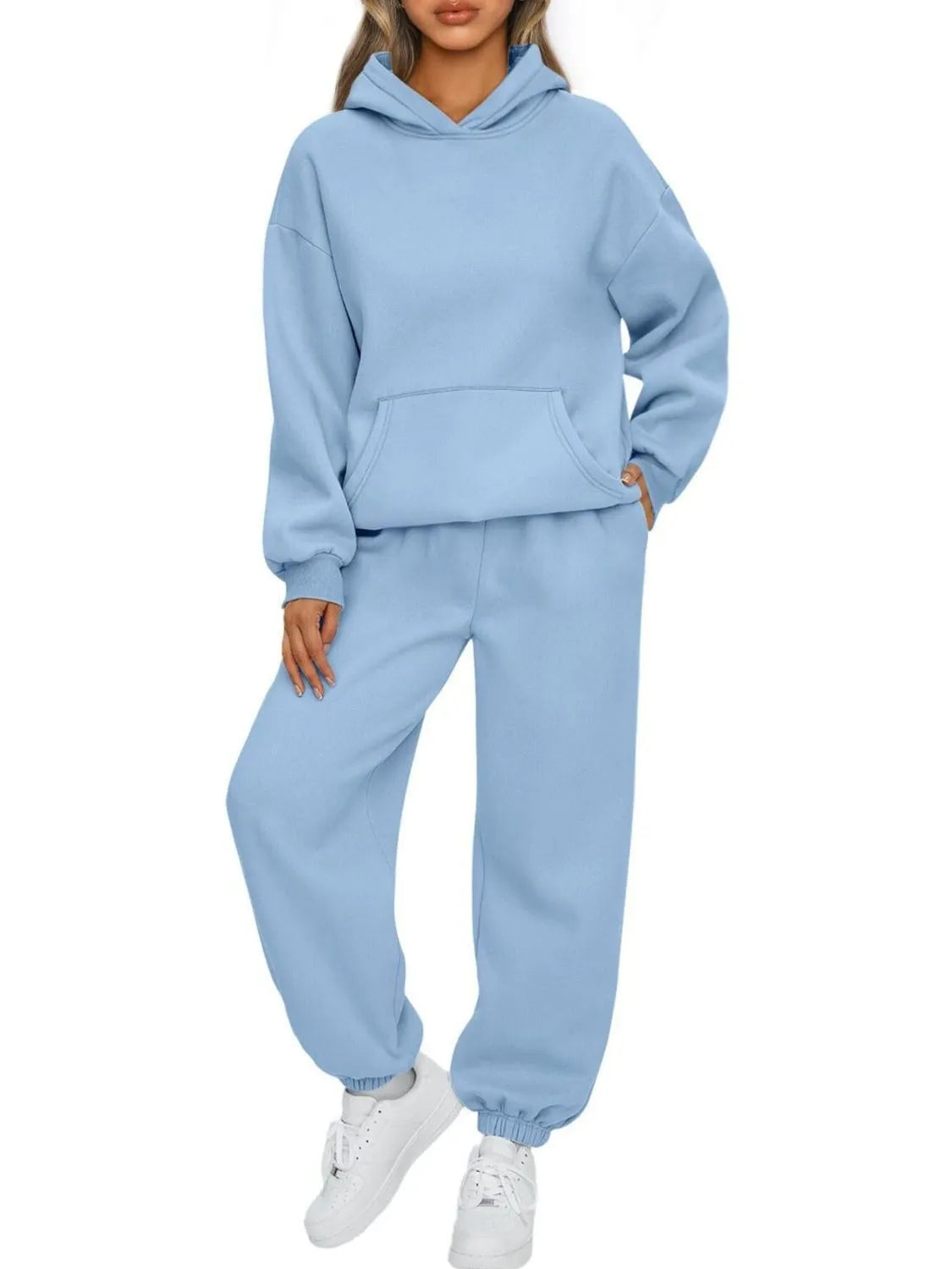 Light blue tracksuit worn by a person on a white background