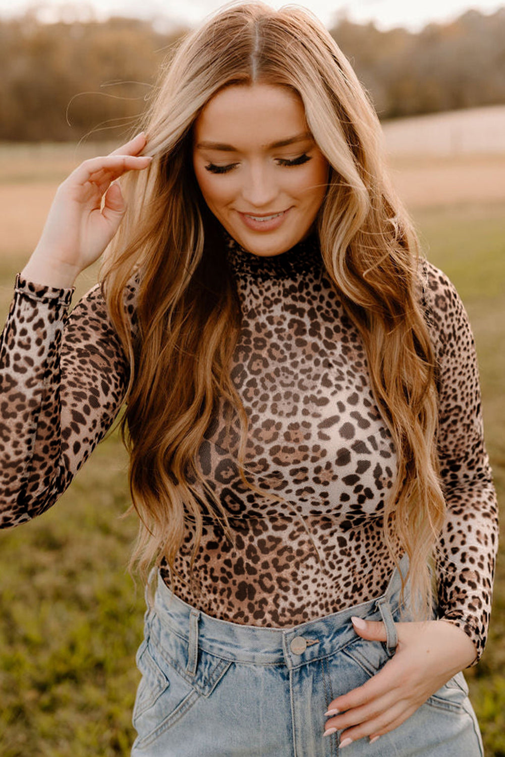 Woman wearing a leopard print top and jeans in an outdoor setting
