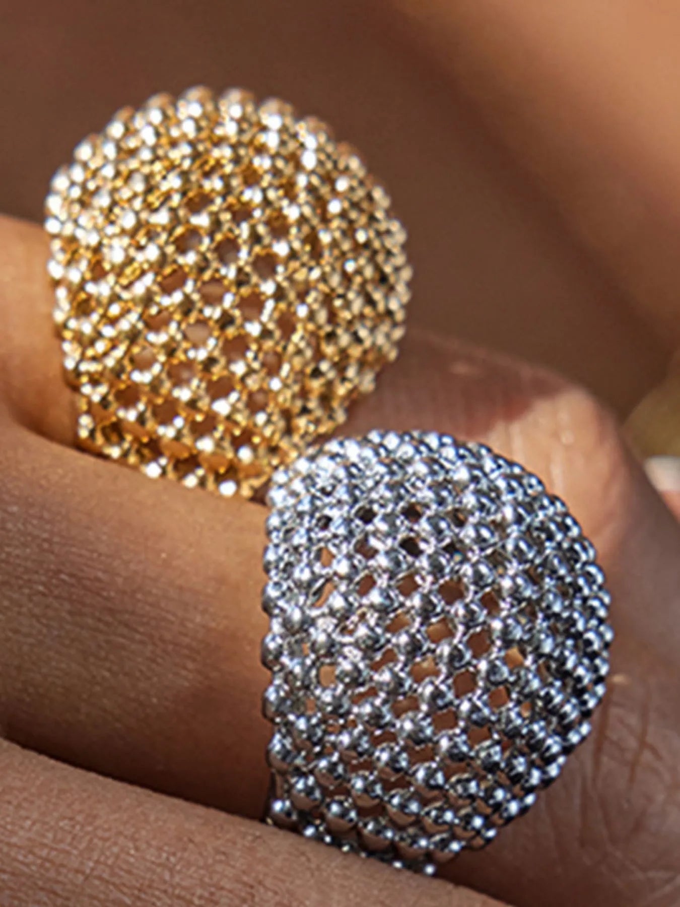 Gold and silver textured ring on a hand