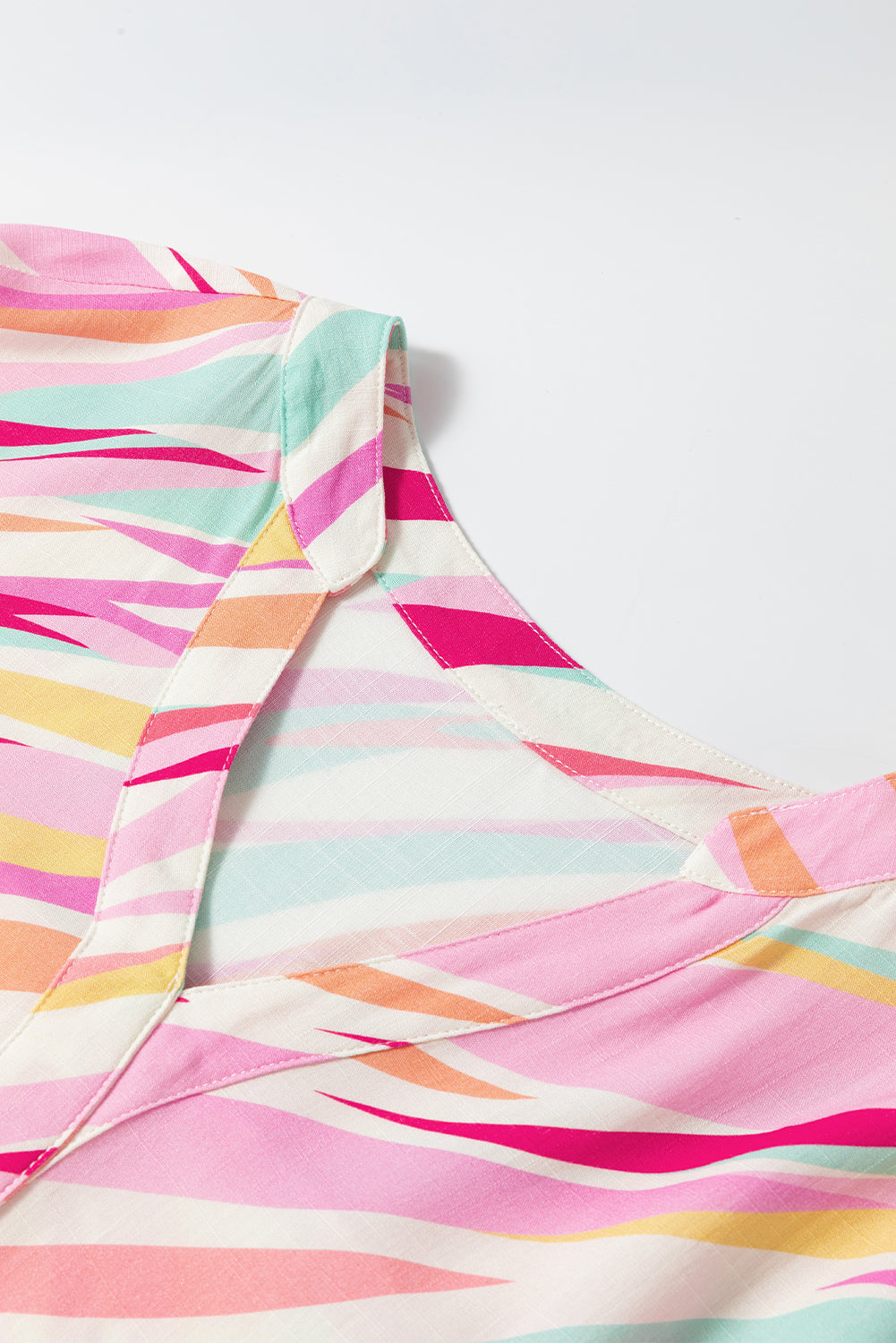 Colorful striped fabric with pink, yellow, and blue pattern on a white background
