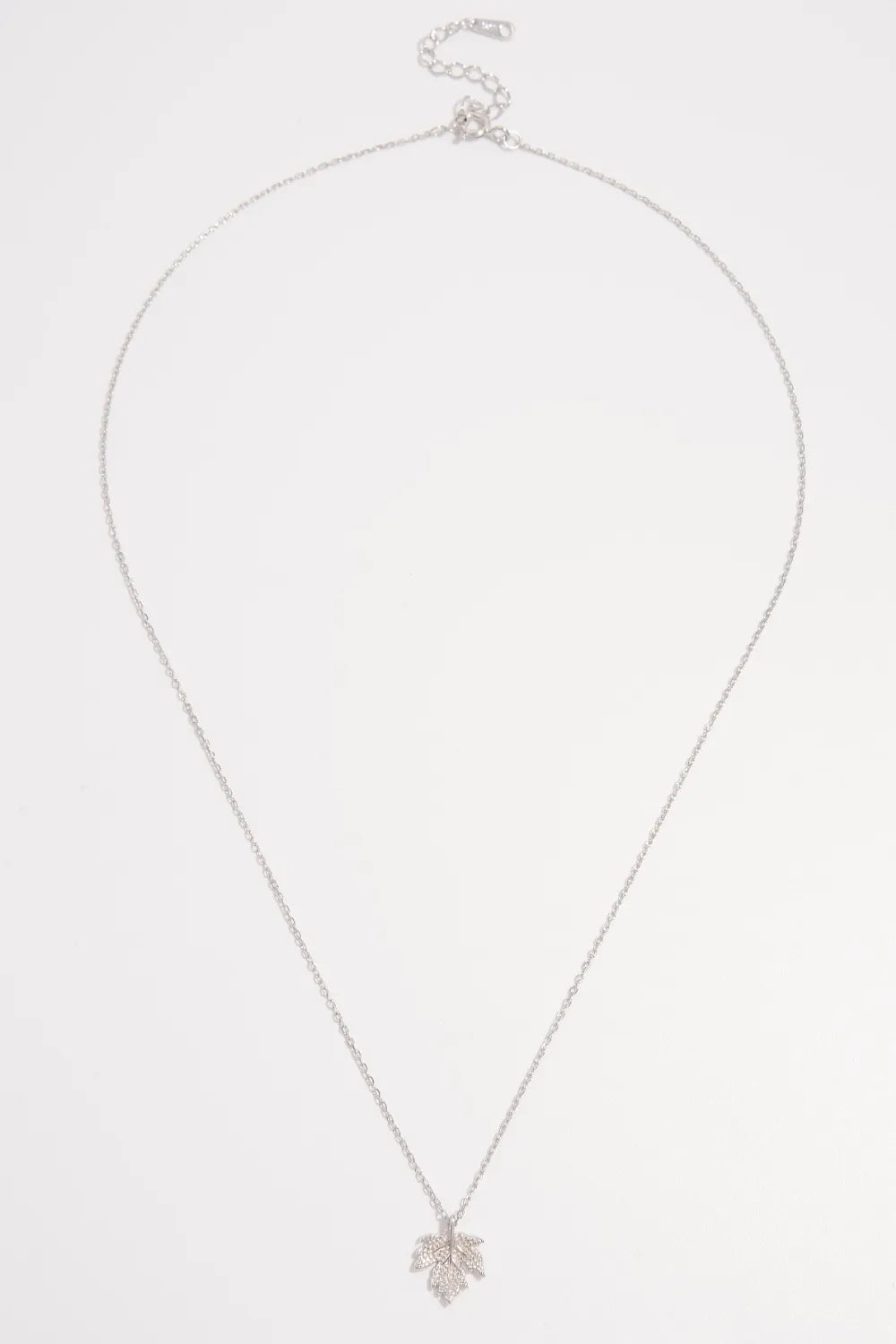 Silver necklace with a small pendant on a white background