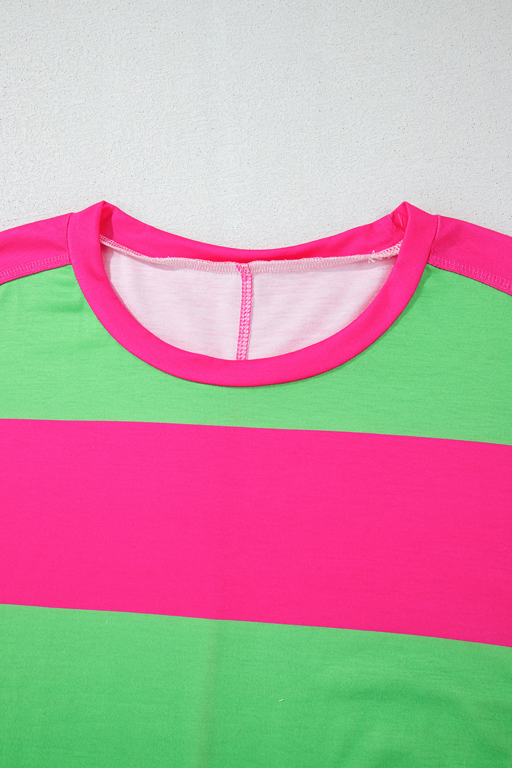 Close-up of a green and pink striped shirt with a plain background