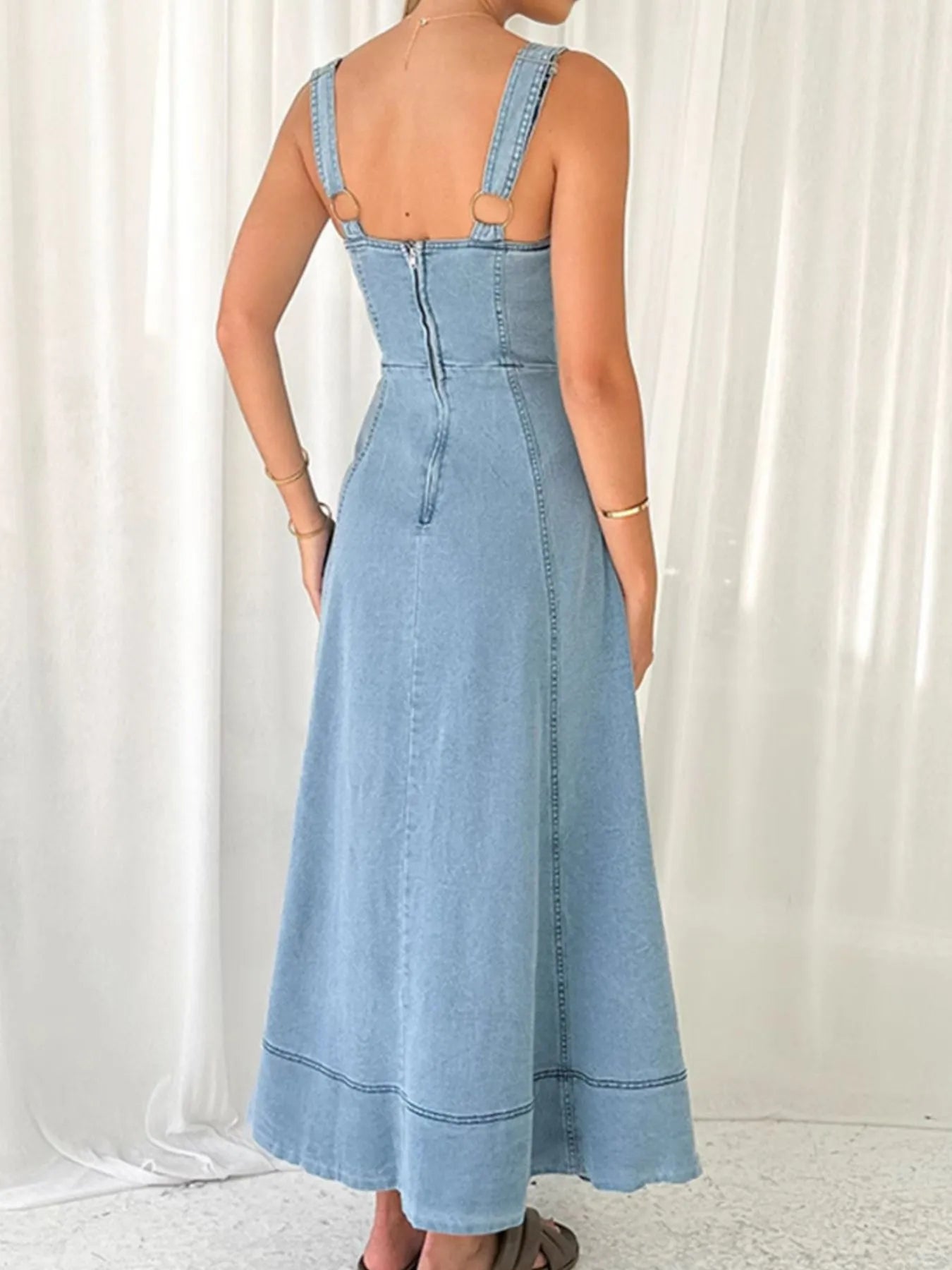 Blue denim dress worn by a person on a white background