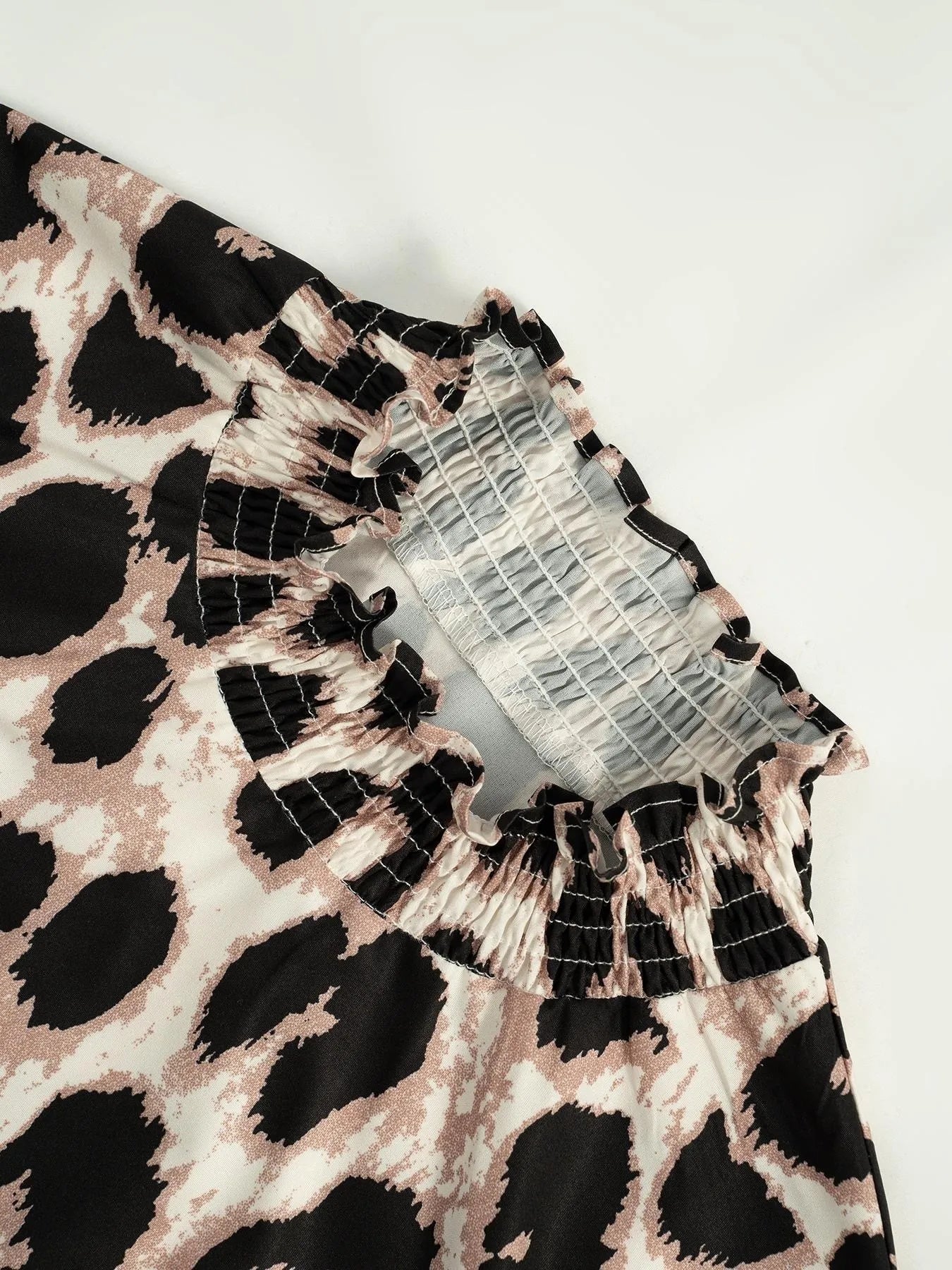 Close-up of a dress with a leopard print and lace details on a white background
