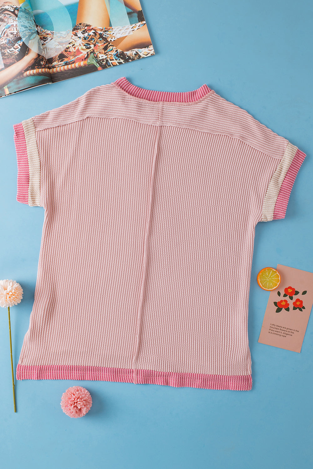 Pink ribbed sweater on a blue background with decorative elements