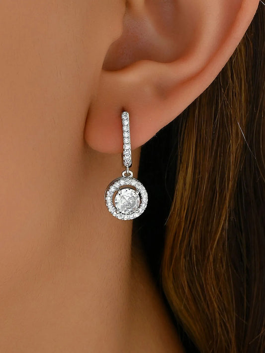 Close-up of a diamond earring on an ear with a blurred background