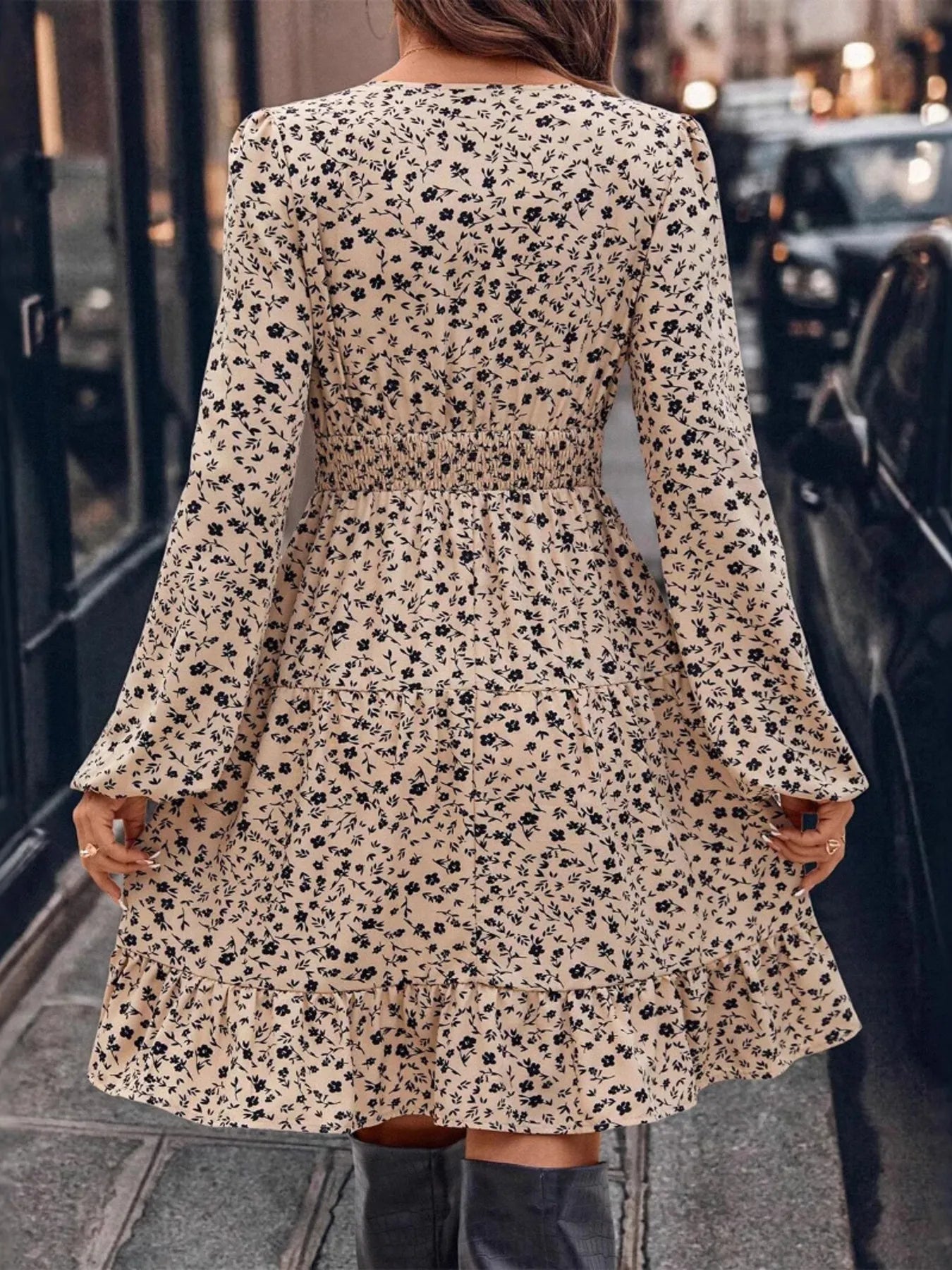 Person wearing a floral dress with long sleeves in an urban setting