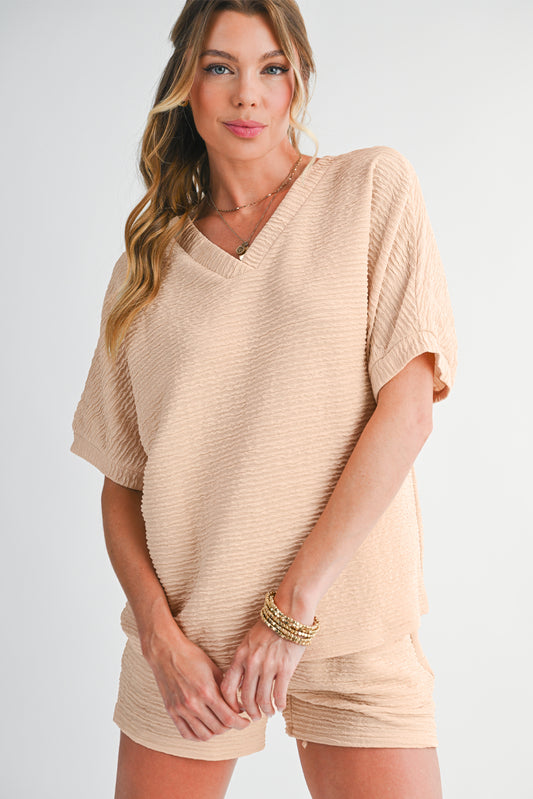 Woman wearing a beige short-sleeve dress on a plain background