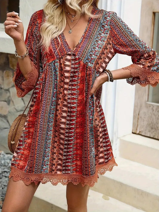 Woman wearing a colorful patterned dress with a stone wall and steps in the background