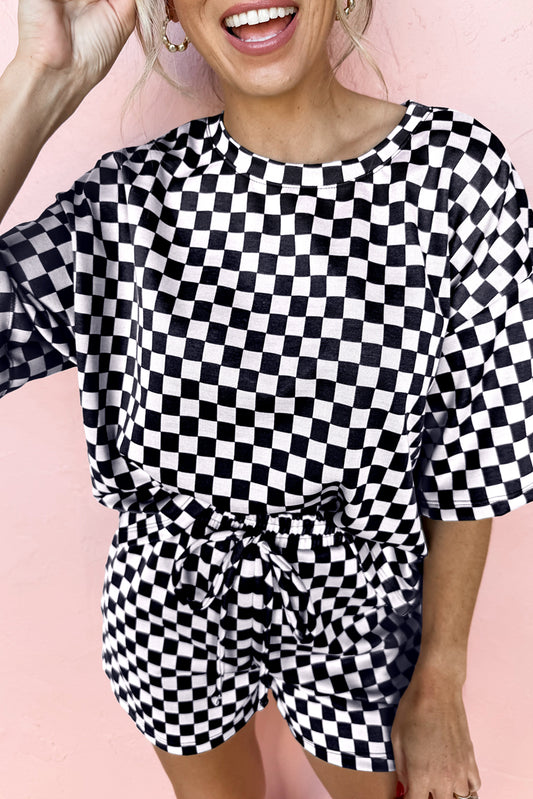 Person wearing a black and white checkered outfit on a pink background