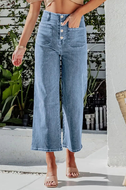 Person wearing light blue wide-leg jeans with a blurred background