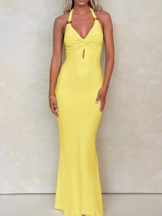 Woman wearing a yellow halter neck dress against a neutral background