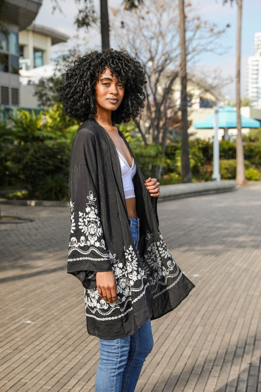 Woman wearing a black embroidered kimono in an urban setting