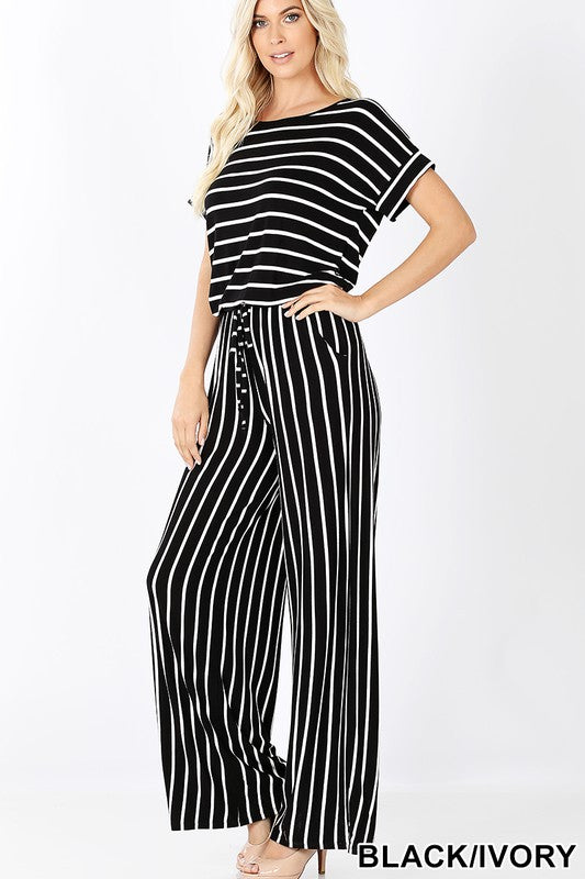 Woman wearing a black and white striped jumpsuit on a white background