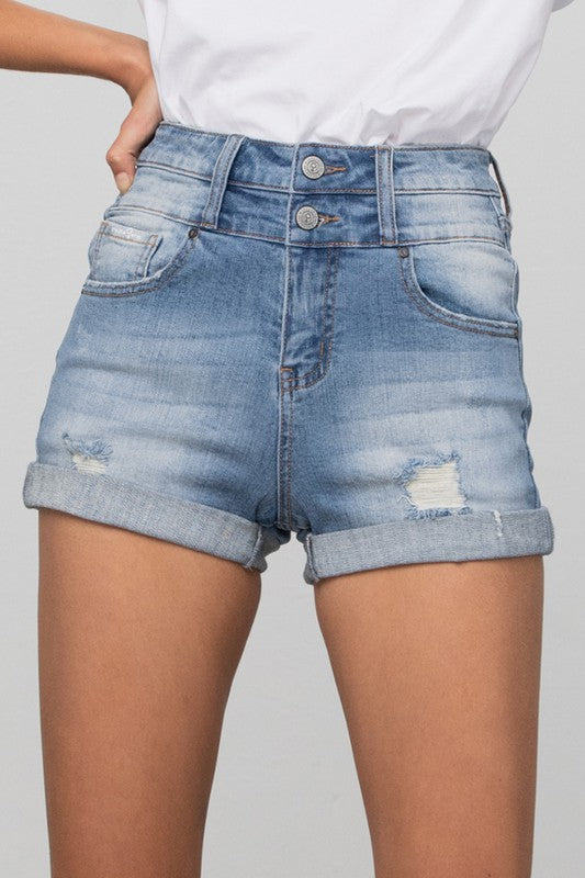 Denim shorts worn by a person on a plain background