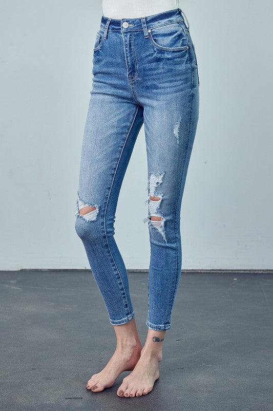 Blue jeans with slight distressing on a plain background