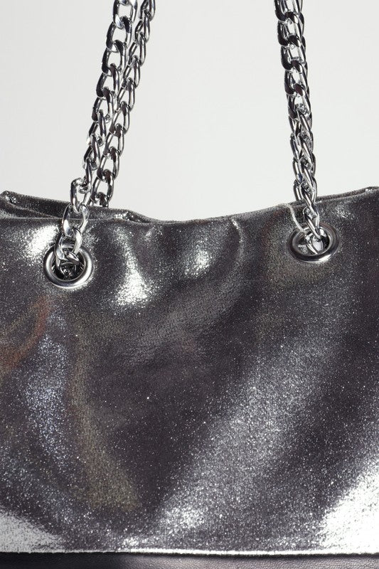 Metallic silver handbag with chain strap on a light gray background