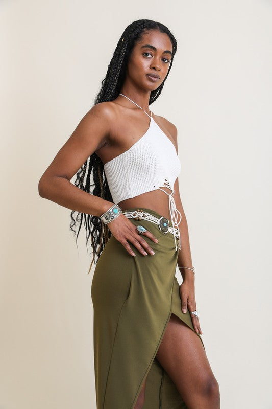 Woman wearing a white top and green skirt against a plain background