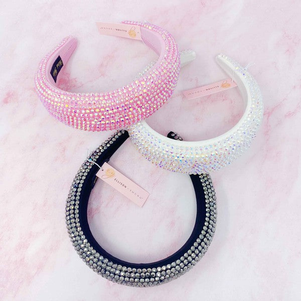 Three decorative headbands with rhinestone embellishments on a pink marble background.