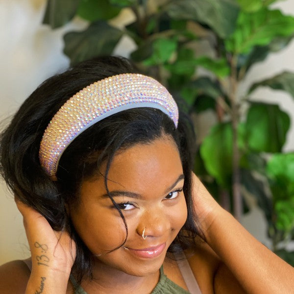 Woman wearing a sparkly headband with plants in the background