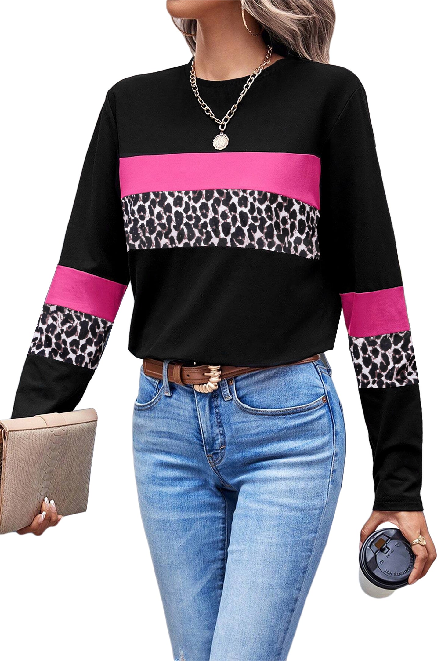 Woman wearing a black sweater with pink and leopard print sleeves and blue jeans.