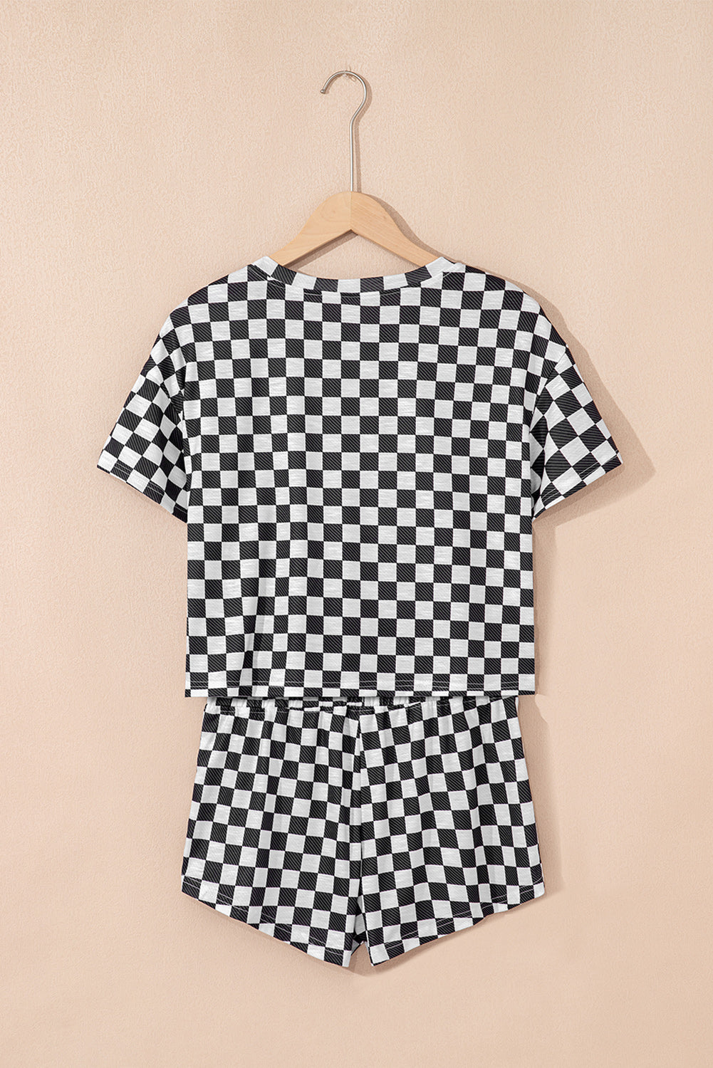 Black and white checkered outfit on a beige background