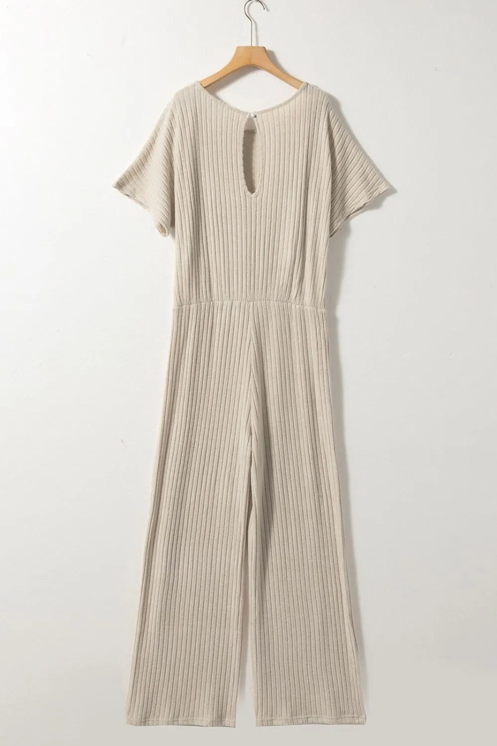 Beige ribbed jumpsuit on a hanger against a white background