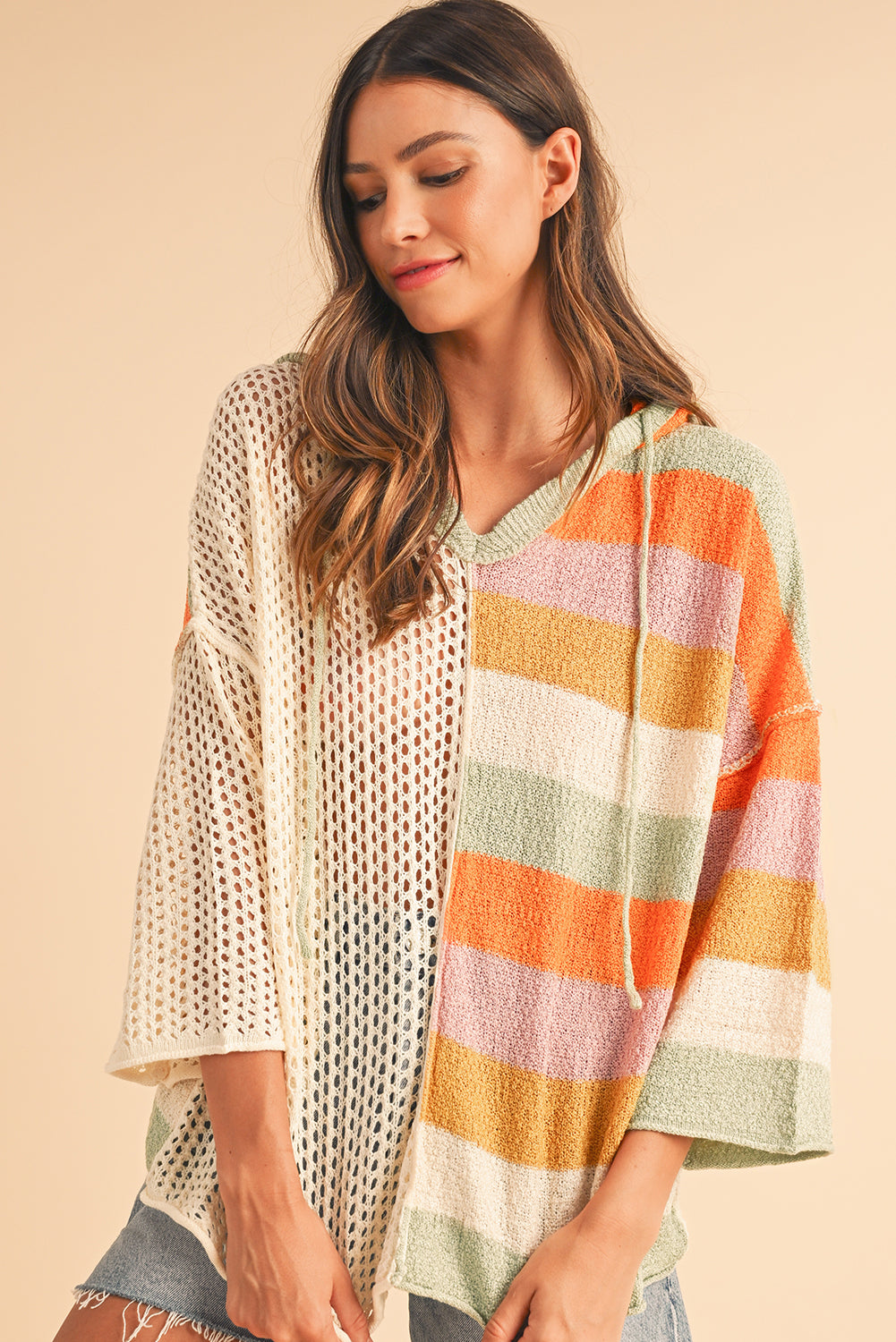 Woman wearing a colorful striped kimono-style garment against a beige background
