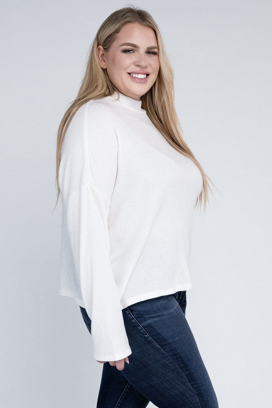 Woman wearing a white blouse and blue jeans against a plain background