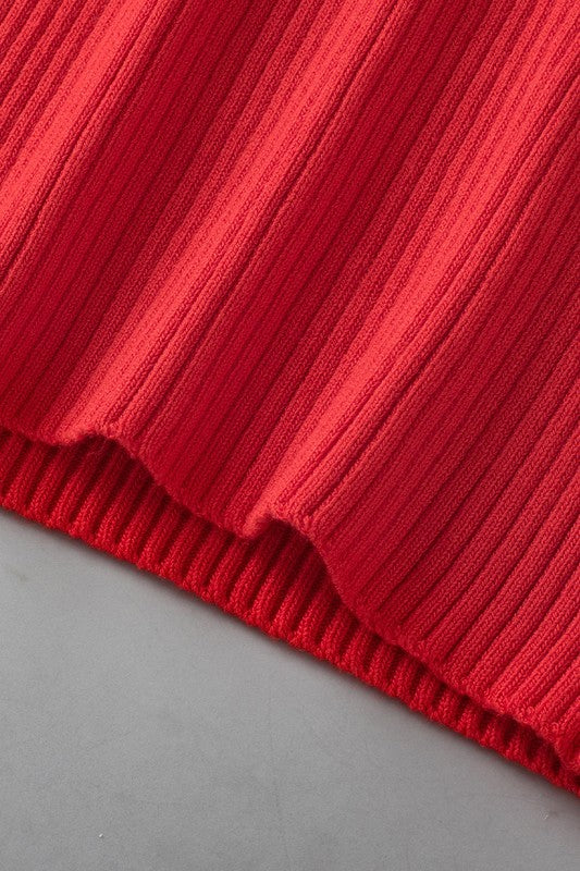 Close-up of a red ribbed fabric edge on a gray background