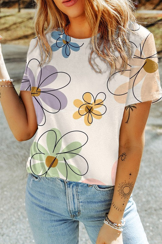 Person wearing a white t-shirt with colorful floral patterns and blue jeans.