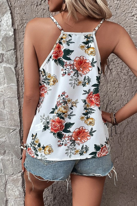 Woman wearing a floral tank top and denim shorts against a stone wall.