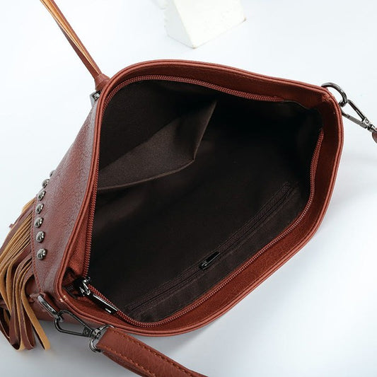 Brown leather handbag with tassels on a white background