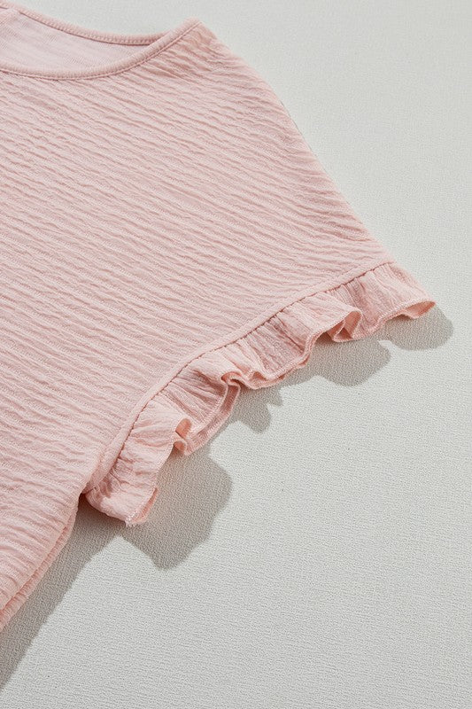 Pink ribbed fabric with ruffled edge on a light gray background