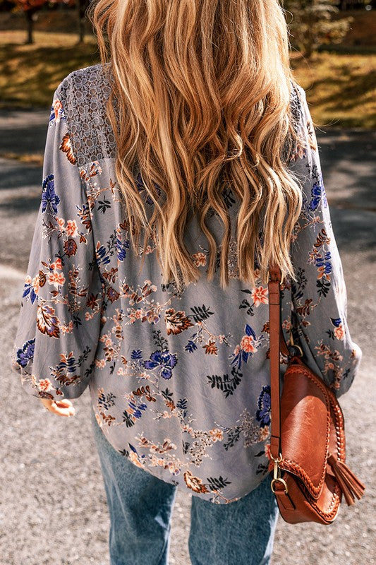 Person wearing a floral kimono with a brown leather bag outdoors