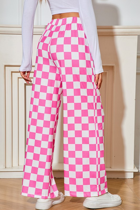 Person wearing pink and white checkered pants with a white top and shoes.