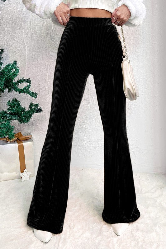 Person wearing black wide-leg pants with a white background