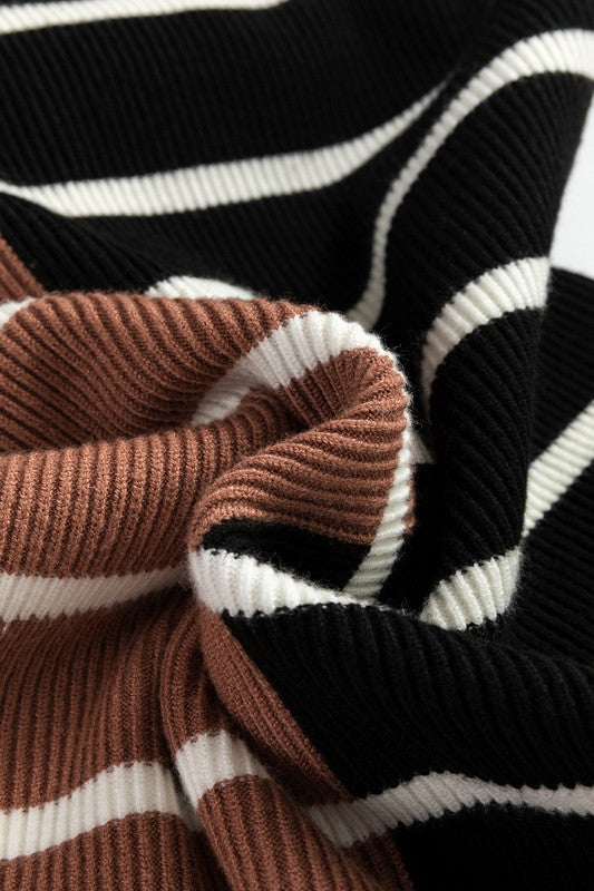 Close-up of ribbed knit fabric with black, white, and brown stripes.
